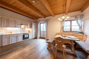 a kitchen with a wooden table and a dining room at Kinderparadies Bachbauer in Mondsee