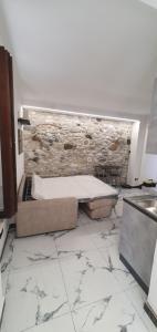 a bathroom with a bed and a stone wall at Maréa suite con giardino in Marina di Carrara +15 photos
