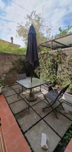a patio with a table and an umbrella and two chairs at Maréa suite con giardino in Marina di Carrara