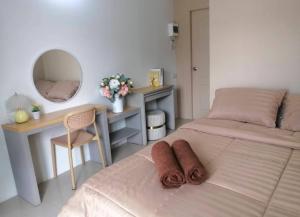 a bedroom with two beds and a desk and a mirror at The City in Ban Si Than