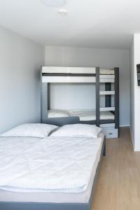 a bedroom with a large bed with white sheets at Apartmán nad pilou in Velké Meziříčí