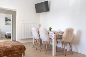 a dining room with a table with fuzzy chairs at Apartmán nad pilou in Velké Meziříčí