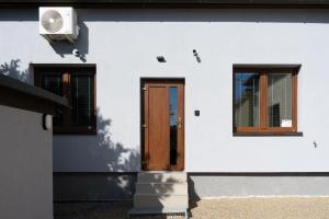 a white building with a door and two windows at Apartmán nad pilou in Velké Meziříčí