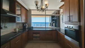 a kitchen with a large window with a view of the ocean at Santorini 402B in Margate +19 photos