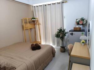 a bedroom with a bed and a desk and a window at The City in Ban Si Than