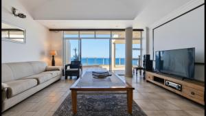 a living room with a couch and a tv at Santorini 402B in Margate