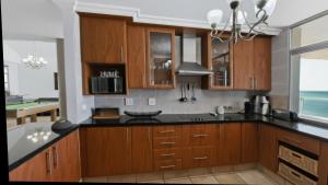 a kitchen with wooden cabinets and black counter tops at Santorini 402B in Margate