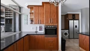 a kitchen with wooden cabinets and a refrigerator at Santorini 402B in Margate