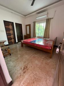 a bedroom with a bed in the middle of a room at Jonaki Shantiniketan in Shānti Niketan