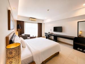 a hotel room with a large bed and a desk at Sakura Park Hotel & Residence in Bekasi