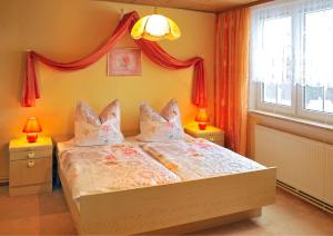 a bedroom with a bed with two lamps and a window at Panoramaferienwohnung Bergwiese in Masserberg