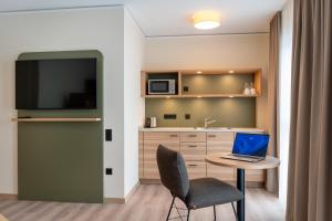 a small kitchen with a table with a laptop on it at Hotel Neue Mitte in Schlüchtern