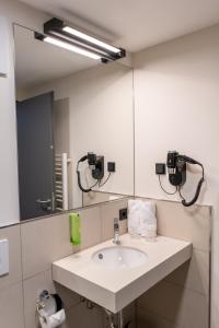 a bathroom with a sink and a mirror at Hotel Neue Mitte in Schlüchtern +5 photos