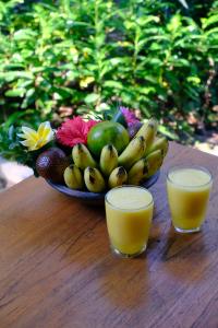 a plate of fruit and two glasses of orange juice at Pondok Ijo Villa in Yogyakarta