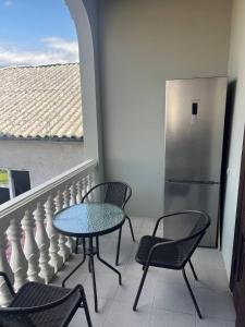 a table and chairs on a balcony with a refrigerator at Chavchavadze 56 in Kobuleti