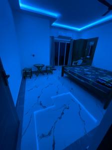 an empty room with blue lights on the floor at Jonaki Shantiniketan in Shānti Niketan +36 photos