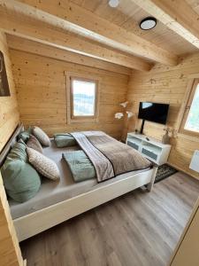 a bedroom with a bed in a log cabin at Modernes Blockhaus mit Sauna Flair in Lisberg