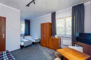 a hotel room with two beds and a television at Ośrodek Wypoczynkowy AS PIK dawniej Hotel AS PIK in Niechorze