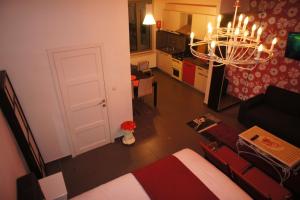 un soggiorno con letto e lampadario pendente di J and R Brussels City Apartment a Bruxelles