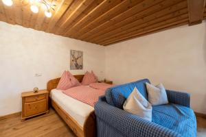 a bedroom with a bed and two blue chairs at Kinderparadies Bachbauer in Mondsee +161 photos