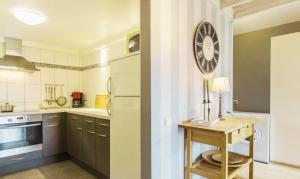 a kitchen with a table and a clock on the wall at Chalet de Cligneval in Malmedy +2 photos