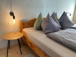 a bedroom with a bed with pillows on it at Sallrain Hof Apartment 2 in Collalbo