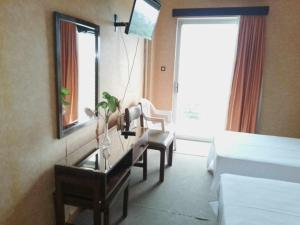a hotel room with a desk and a mirror at HOTEL ALEXANDROS in Loutraki