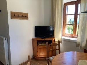 a living room with a television and a table and a window at Sallrain Hof Apartment 2 in Collalbo