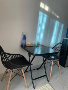 a glass table and two chairs sitting next to a window at royalnest bnb in Mombasa