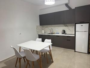 a kitchen with a table and chairs and a refrigerator at Dania Sea View Apartments in Sarandë