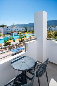 a table and chairs on a balcony with a view of a pool at Zorbas Beach Hotel in Tigaki