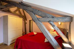 a bedroom with a red bed with wooden beams at Moulin neuf de combecave pour 6 in Saint-Amand-de-Vergt