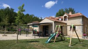 a yard with a playground with a slide at Moulin neuf de combecave pour 4 in Saint-Amand-de-Vergt