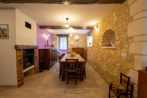 a dining room with a table and a stone wall at Moulin neuf de combecave pour 4 in Saint-Amand-de-Vergt