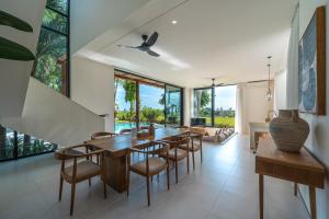a dining room with a long wooden table and chairs at Sealuna Villas in Tanah Lot