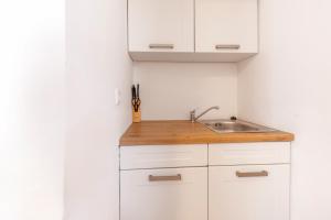 a kitchen with white cabinets and a sink at Guesthouse Villa Adria in Malinska