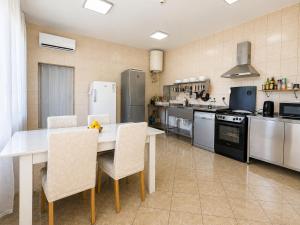 a kitchen with a table and chairs and a refrigerator at Apartment Orange Blossom First Line & Pool 1 in Bijela