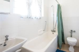 a bathroom with a tub and a toilet and a sink at La Ballito 402 in Ballito