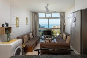 a living room with a couch and a tv and a window at La Ballito 402 in Ballito +1 photo