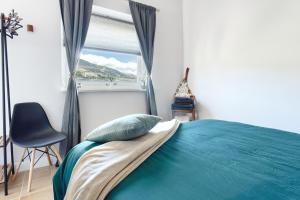 a bedroom with a bed with a blue blanket and a window at La Luna in Jijona +20 photos