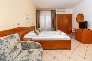 a hotel room with a bed and a couch at Guesthouse Villa Adria in Malinska