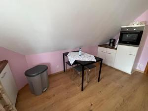 a small kitchen with a table and a small kitchen with pink walls at Ferienwohnung Ahrtalfreude in Sinzig +6 photos