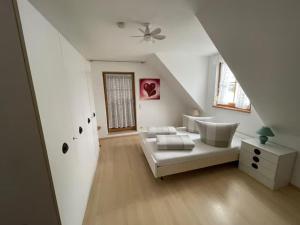 a white living room with a white couch and a window at Ferienwohnung Ahrtalfreude in Sinzig
