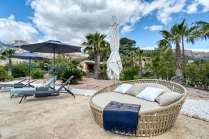 a wicker chair and a wicker bed on a patio at La Luna in Jijona