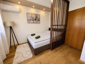 a small bedroom with a bed and a lamp at SkyLux Premium Zenica in Zenica