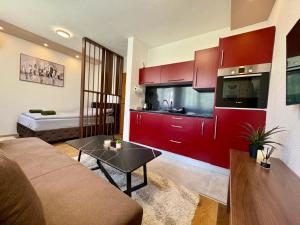 a living room with red cabinets and a kitchen at SkyLux Premium Zenica in Zenica