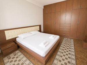 a bedroom with a bed with wooden cabinets at Berat Skyline Apartment in Berat