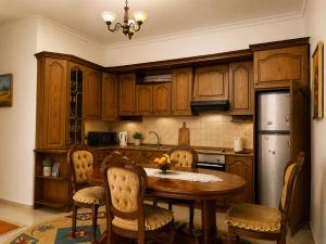 a kitchen with a wooden table and a refrigerator at Berat Skyline Apartment in Berat