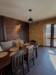 a dining room with a table and a couch at Meiranu krasts in Bērzgale