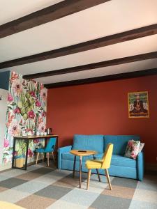 a living room with a blue couch and two chairs at Przystanek Tleń in Tleń